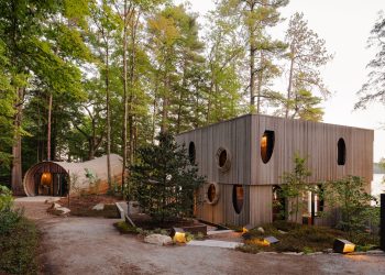 Na czerwonej blachodachówce tańczą jesienne liście niesione podmuchami wiatru