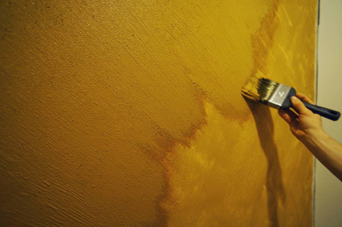 Mieszanie glinki z farbą bazową Naturalna glinka w proszku wsypywana do białej farby w plastikowym wiadrze