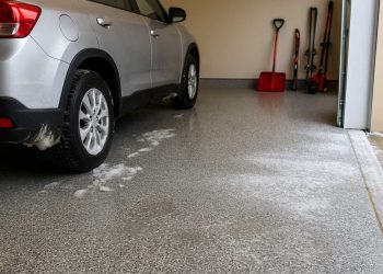 Błyszcząca podłoga epoksydowa w garażu z zaparkowanym samochodem i półkami