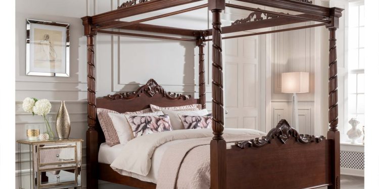 W królewskiej sypialni stoi majestatyczne łóżko z jedwabnym baldachimem w kolorze burgundu