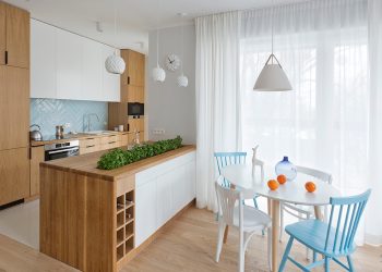 Nowoczesny aneks kuchenny z oświetleniem sufitowym pod szafkami i wiszącymi lampami