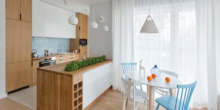 Nowoczesny aneks kuchenny z oświetleniem sufitowym pod szafkami i wiszącymi lampami