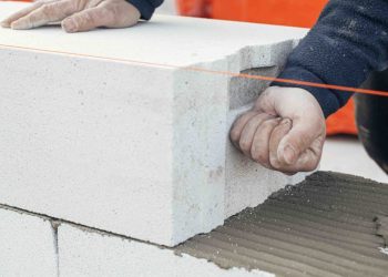 Stos białych bloków betonu komórkowego z porowatą strukturą na placu budowy