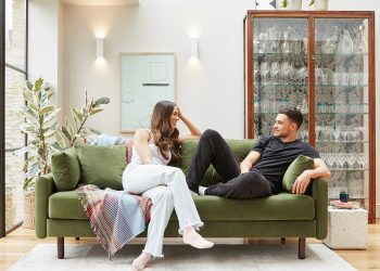 Nowoczesny salon z modułową sofą L-kształtną, regałami i stolikiem w szarych tonach