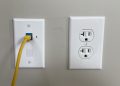nowoczesne mieszkanie z białą puszką i kablem Ethernet wystającym ze ściany