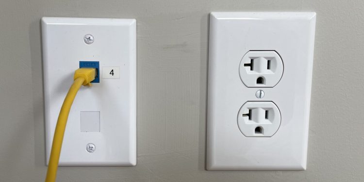 nowoczesne mieszkanie z białą puszką i kablem Ethernet wystającym ze ściany