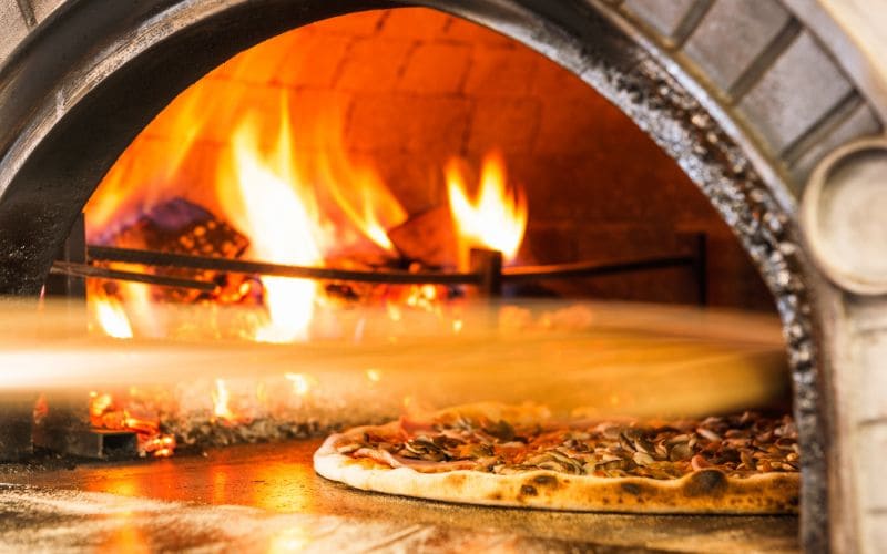 roztopiony ser i pieczone warzywa na pizzy w piecu