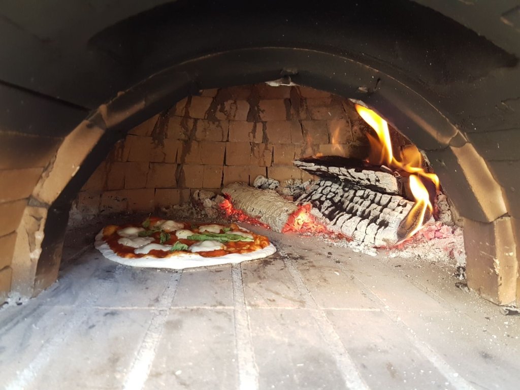 płomienie buzujące w kominku pieca do pizzy z drewna