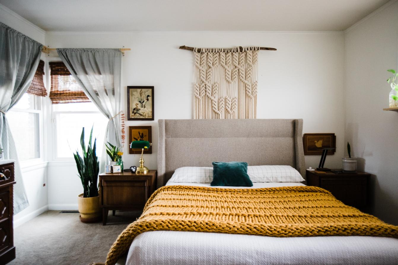 Okrągłe boho lustro nad drewnianą konsolą przy ścianie